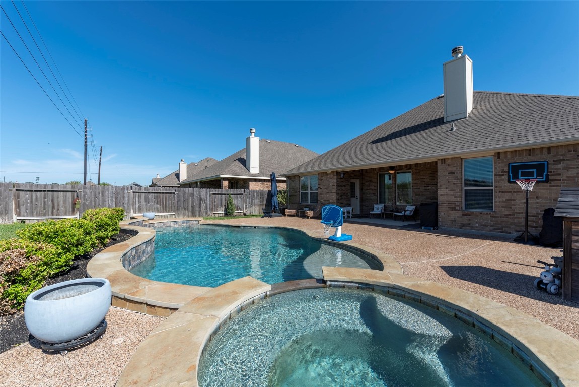 22939 Banff Brook Way Tomball, TX 77375 - Photo 21 of 25 Resort-style pool with integrated spa, surrounded by a spacious deck and private fencing for ultimate enjoyment.