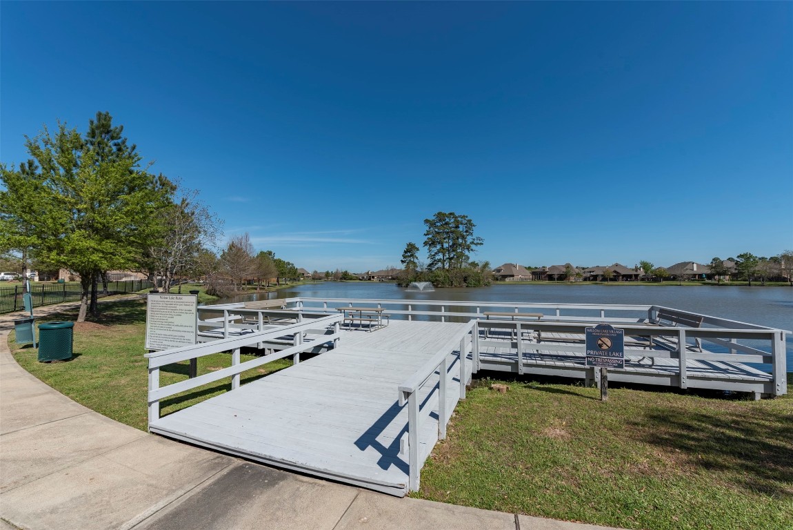 22939 Banff Brook Way Tomball, TX 77375 - Photo 24 of 25 Peaceful neighborhood lake featuring a private dock with seating—perfect for relaxing or enjoying scenic water views.