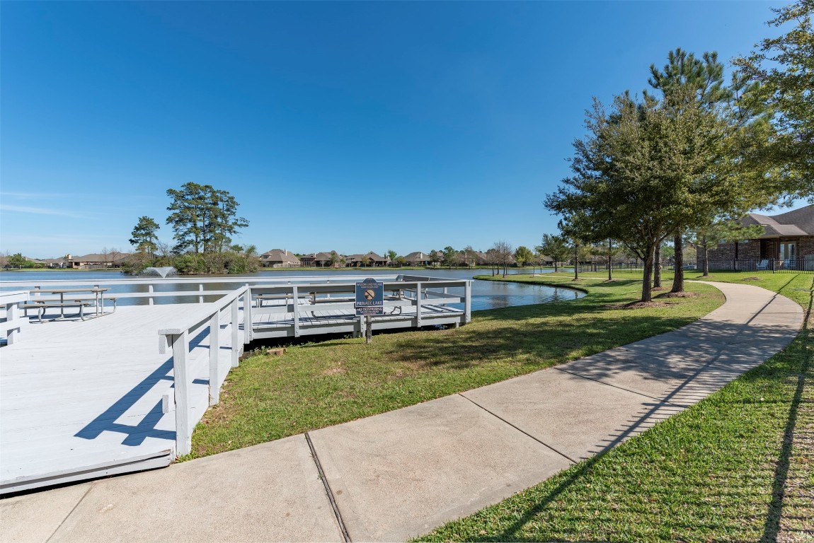 22939 Banff Brook Way Tomball, TX 77375 - Photo 25 of 25 Beautiful walking path wraps around the lake, offering serene views and a perfect setting for morning strolls or evening walks.