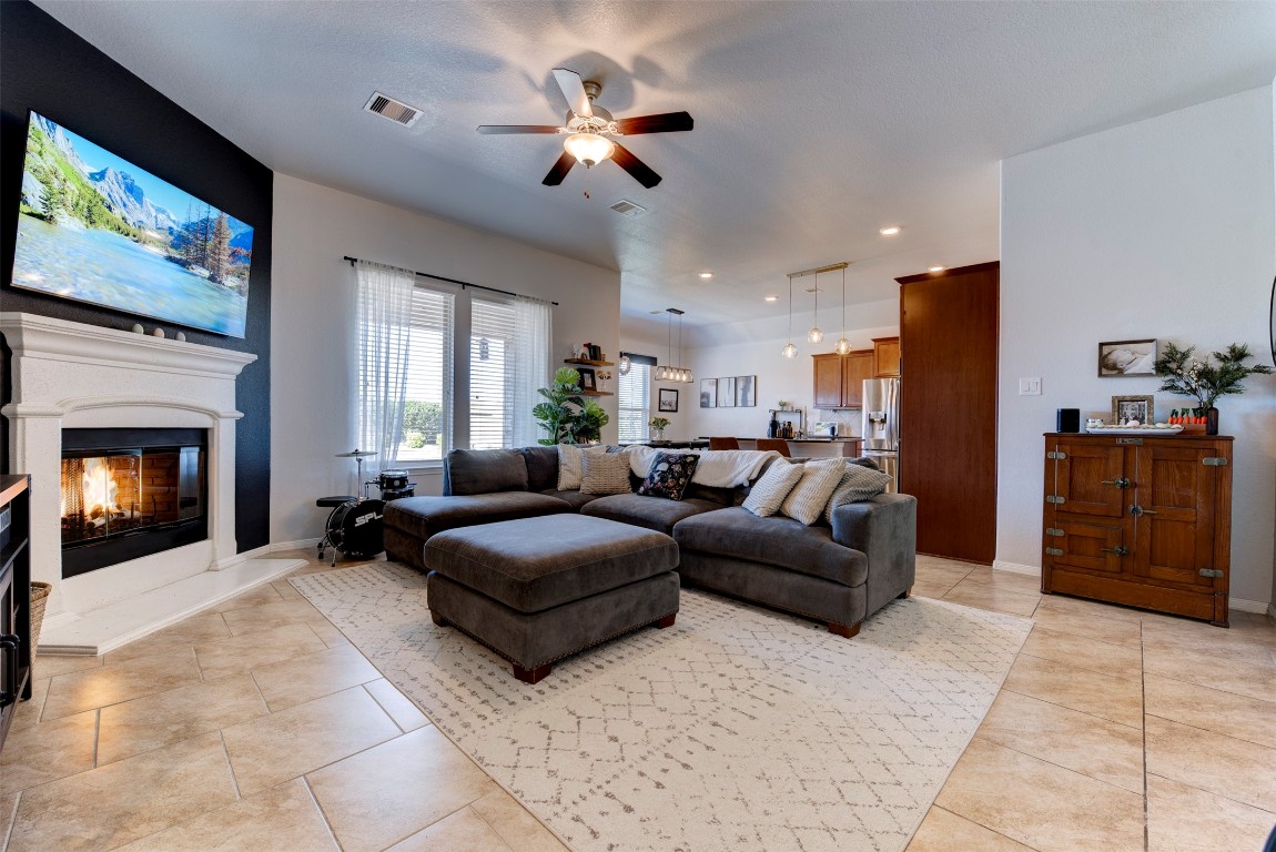 22939 Banff Brook Way Tomball, TX 77375 - Photo 6 of 25 Expansive living area with large windows, fireplace focal point, and open sightlines to the dining and kitchen areas.
