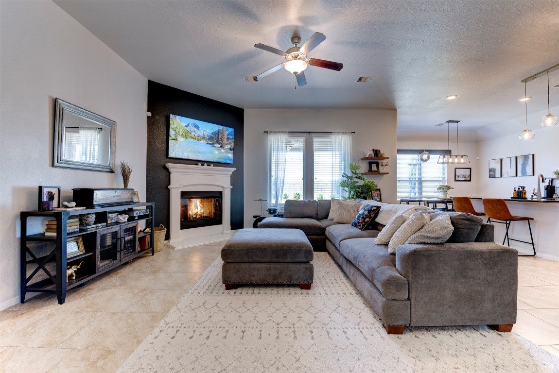 22939 Banff Brook Way Tomball, TX 77375 - Photo 7 of 25 Inviting living room centered around a cozy fireplace, creating a warm and comfortable gathering space.