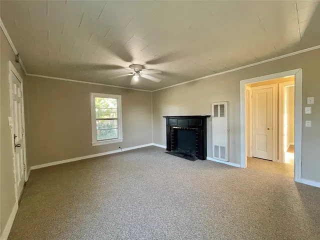 an empty room with windows and fireplace