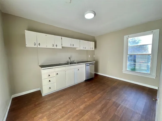 a kitchen with cabinets wooden floor and a sink