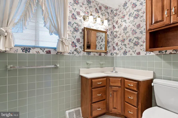 a bathroom with a granite countertop sink a toilet and a mirror