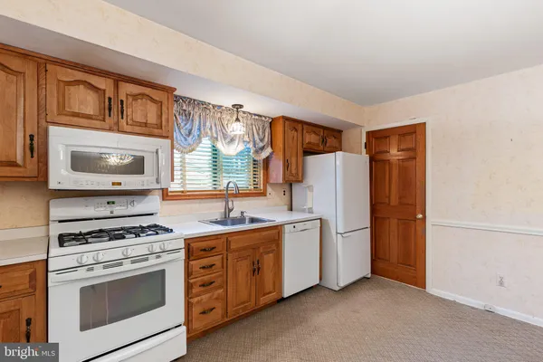 a kitchen with white cabinets and white appliances