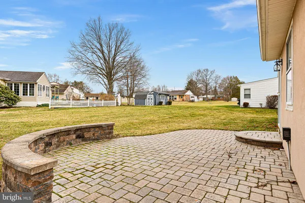 a view of swimming pool with lawn chairs and large trees