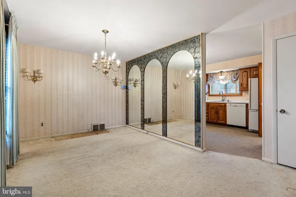 an empty room with chandelier and glass door