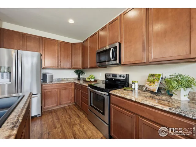 a kitchen with granite countertop a refrigerator sink and microwave