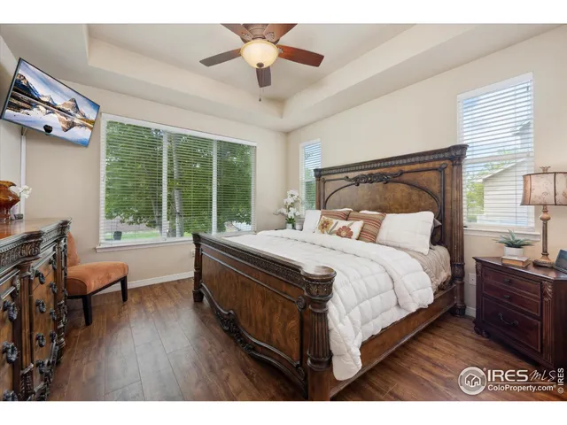 a bedroom with a large bed and a chandelier fan