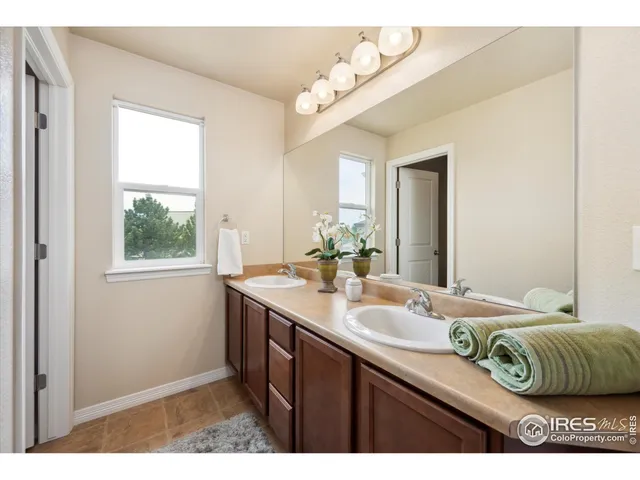 a en suite bathroom with a sink mirror and window