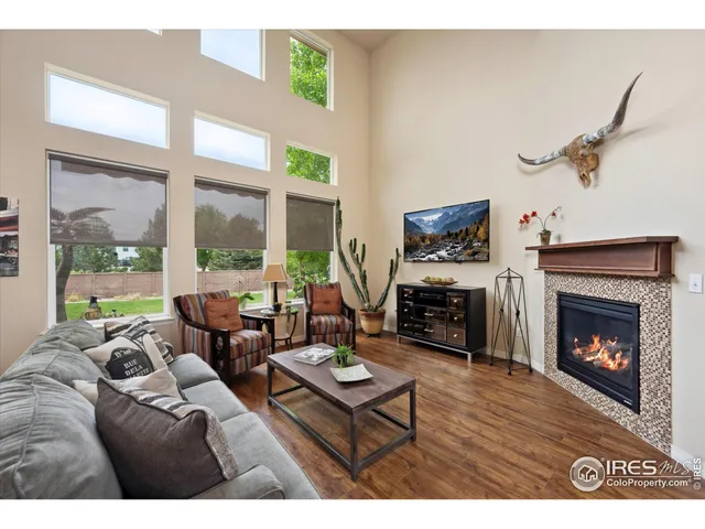 a living room with furniture a fireplace and a floor to ceiling window