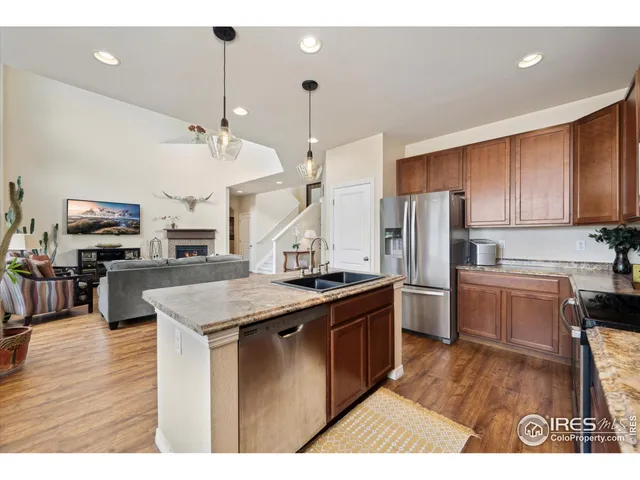a kitchen with stainless steel appliances granite countertop a sink a stove and a refrigerator