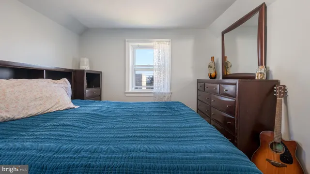 a bedroom with wooden floor and bed