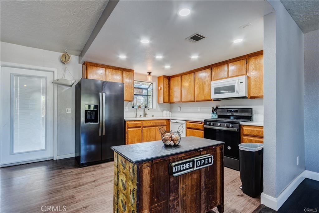 10971 Adobe Road Oak Hills, CA 92344 - Photo 14 of 49 a kitchen with stainless steel appliances granite countertop a refrigerator a stove and a sink