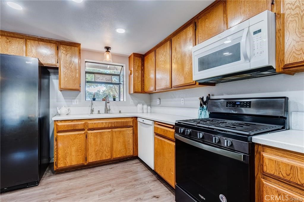 10971 Adobe Road Oak Hills, CA 92344 - Photo 15 of 49 a kitchen with stainless steel appliances granite countertop a stove a sink and a microwave