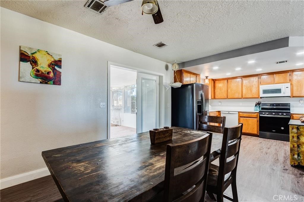 10971 Adobe Road Oak Hills, CA 92344 - Photo 18 of 49 a view of a dining room with furniture window and wooden floor