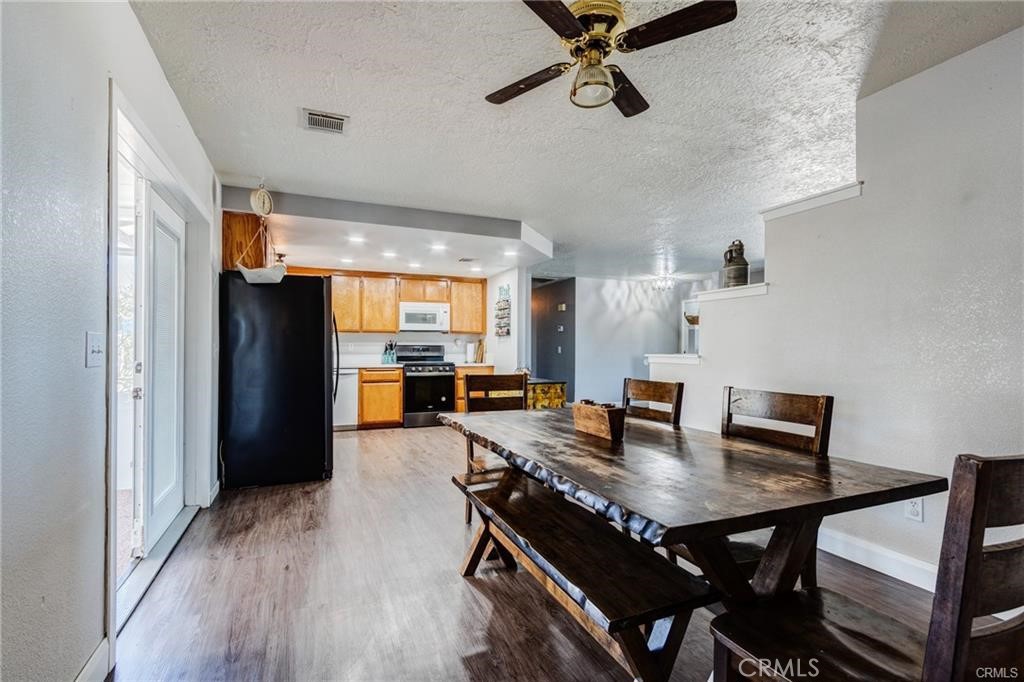 10971 Adobe Road Oak Hills, CA 92344 - Photo 20 of 49 a view of a dining room with furniture and wooden floor