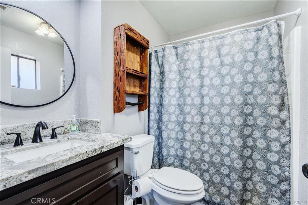 10971 Adobe Road Oak Hills, CA 92344 - Photo 26 of 49 a bathroom with a granite countertop sink and a mirror