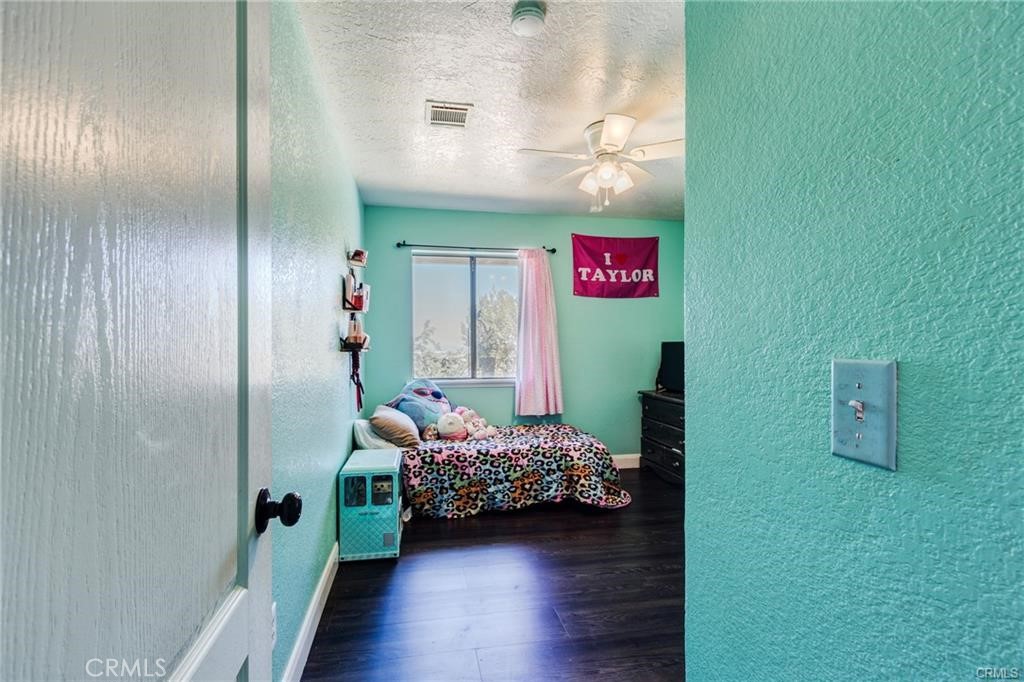 10971 Adobe Road Oak Hills, CA 92344 - Photo 28 of 49 a bedroom with a bed and a potted plant