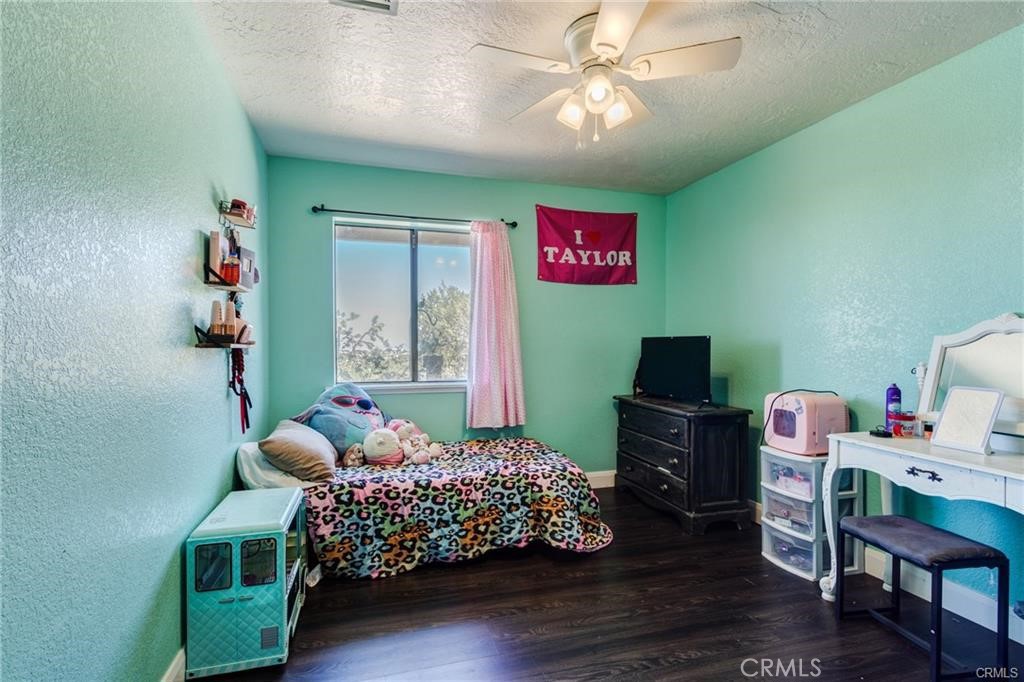 10971 Adobe Road Oak Hills, CA 92344 - Photo 29 of 49 a bedroom with a bed and a chandelier