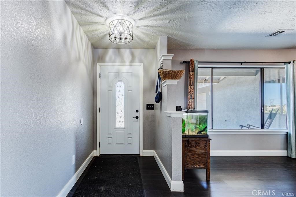 10971 Adobe Road Oak Hills, CA 92344 - Photo 8 of 49 a view of an entryway with wooden floor and a chandelier