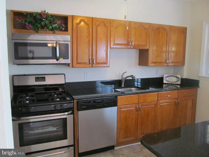 905 Southridge Road Catonsville, MD 21228 - Photo 8 of 14 a kitchen with stainless steel appliances granite countertop a stove a microwave and a sink