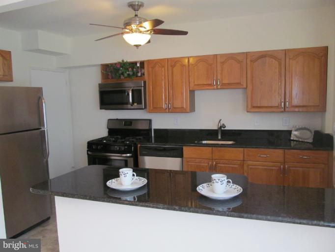905 Southridge Road Catonsville, MD 21228 - Photo 9 of 14 a kitchen with stainless steel appliances granite countertop a sink and a stove