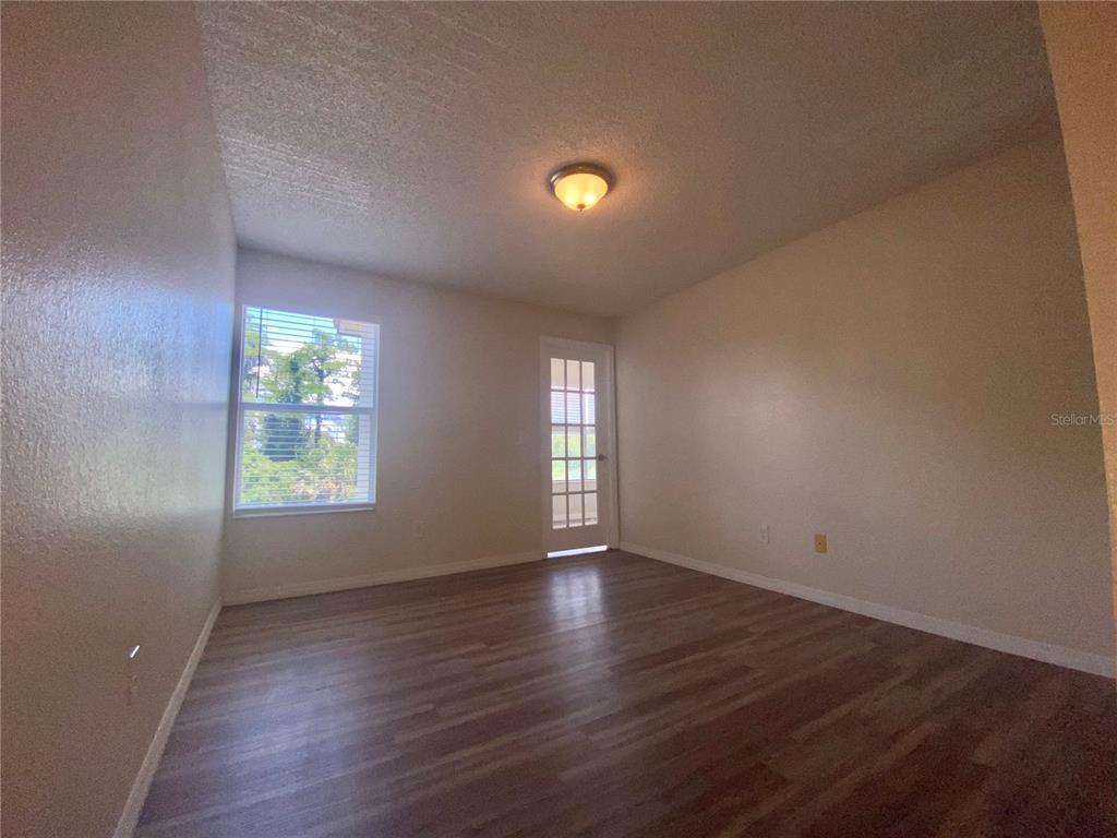 5144 Conroy Road, Unit 38 Orlando, FL 32811 - Photo 17 of 49 an empty room with wooden floor and windows