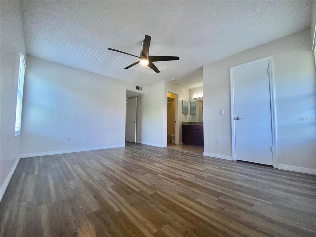 5144 Conroy Road, Unit 38 Orlando, FL 32811 - Photo 20 of 49 a view of empty room with wooden floor and ceiling fan