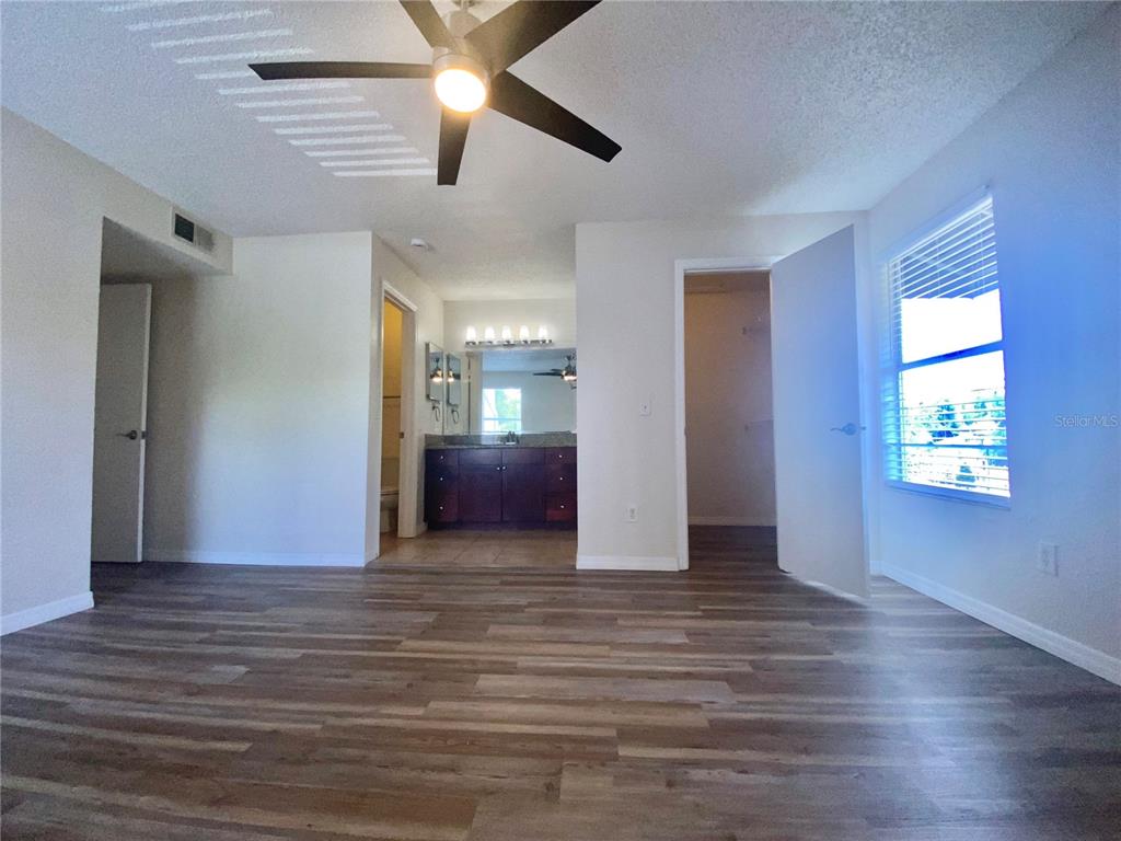 5144 Conroy Road, Unit 38 Orlando, FL 32811 - Photo 21 of 49 an empty room with wooden floor and windows