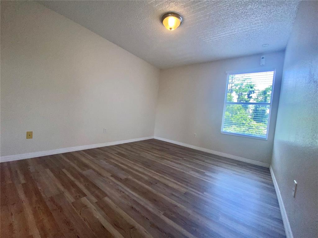 5144 Conroy Road, Unit 38 Orlando, FL 32811 - Photo 48 of 49 an empty room with wooden floor and windows