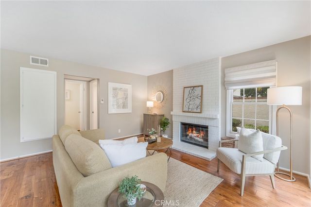 a living room with furniture fireplace and wooden floor