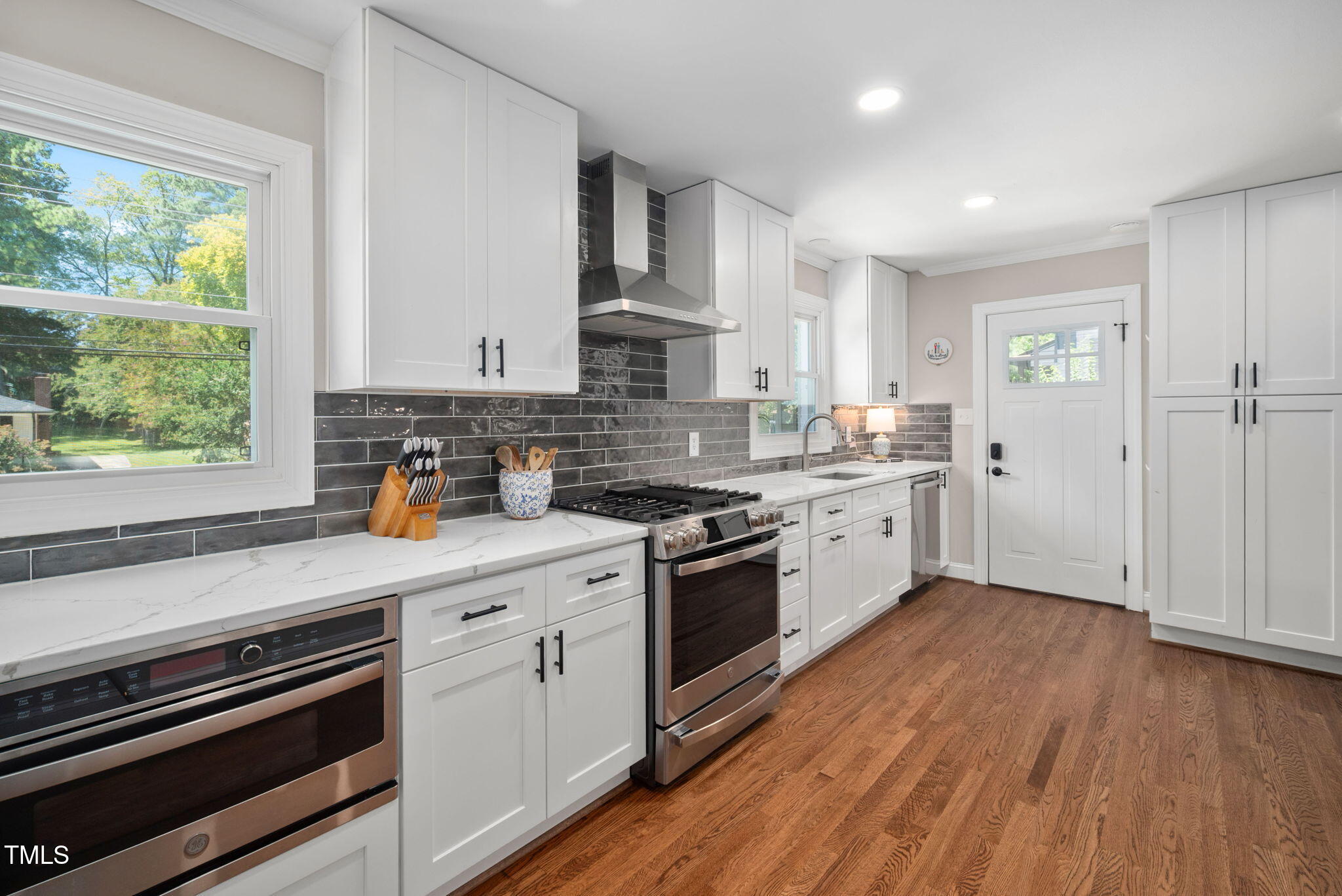 4808 Latimer Road Raleigh, NC 27609 - Photo 14 of 39 a kitchen with stainless steel appliances white cabinets and wooden floors