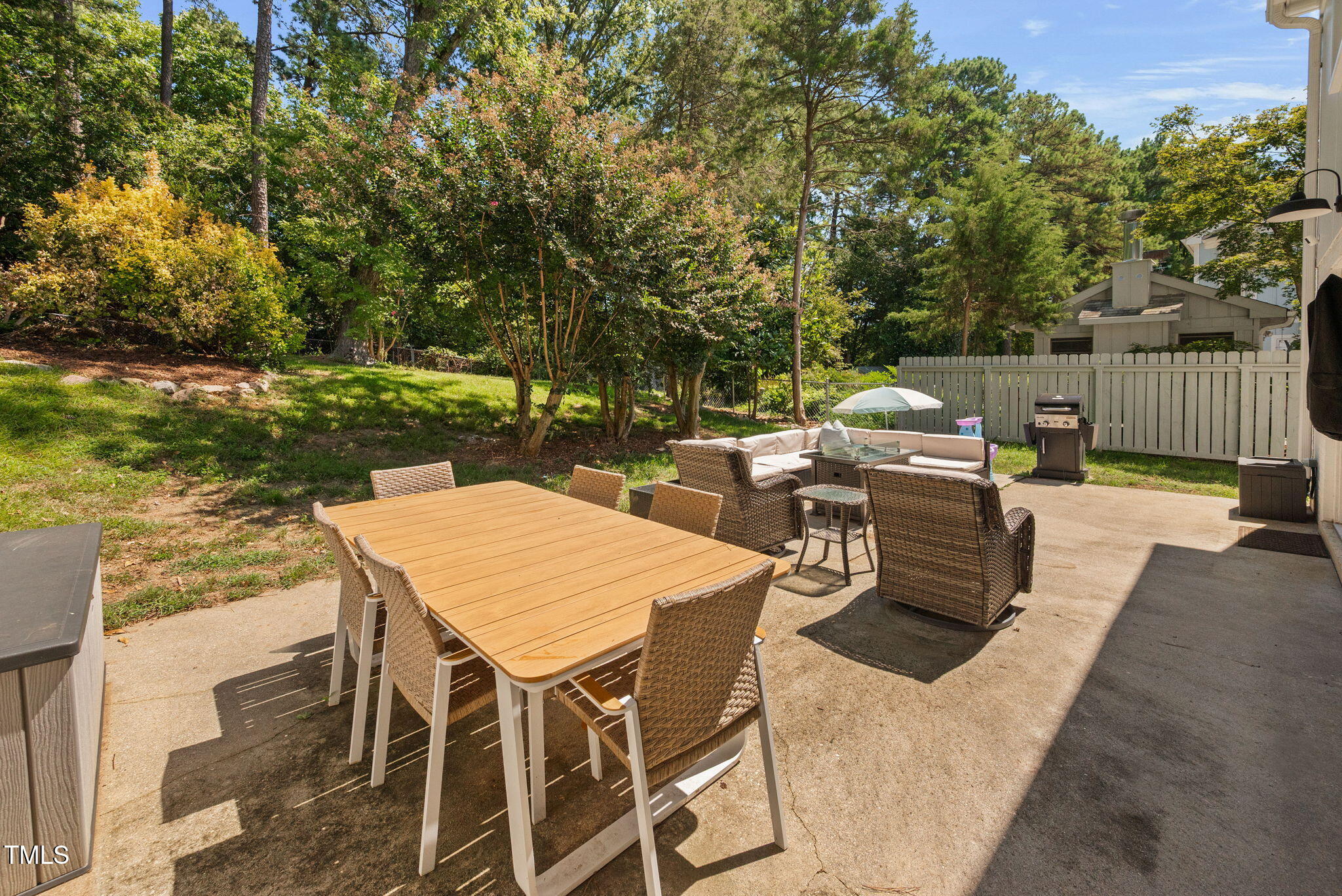 4808 Latimer Road Raleigh, NC 27609 - Photo 32 of 39 a patio with table and chairs with potted plants and large trees