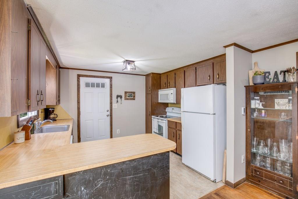 81 Newbury Road Rowley, MA 01969 - Photo 7 of 25 a kitchen with a refrigerator a stove and a sink