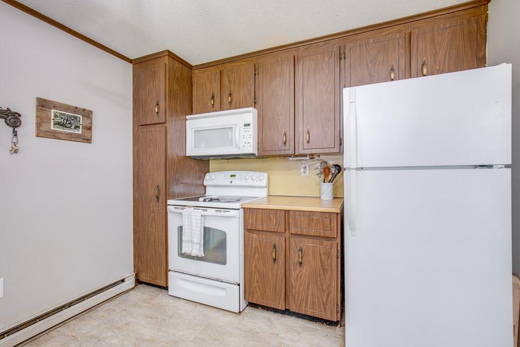 81 Newbury Road Rowley, MA 01969 - Photo 8 of 25 a white refrigerator freezer sitting in a kitchen