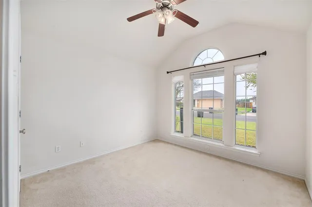 an empty room with windows and fan