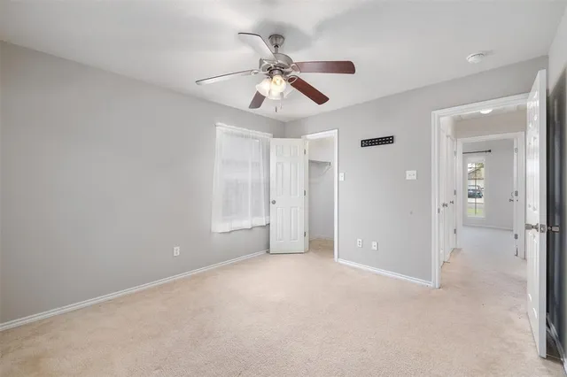 an empty room with closet and a ceiling fan