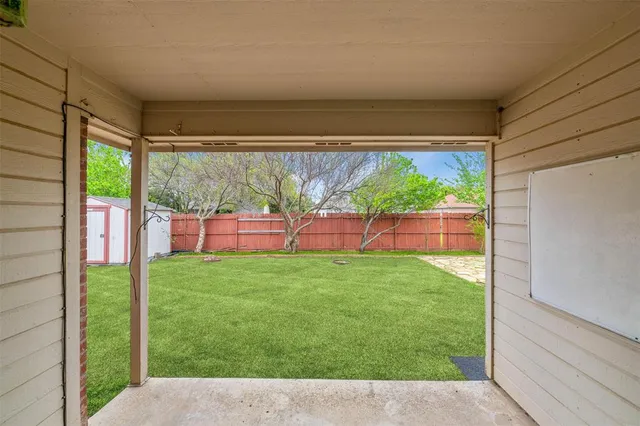 a view of backyard with large trees and plants