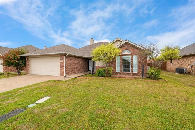 a front view of a house with a garden and yard
