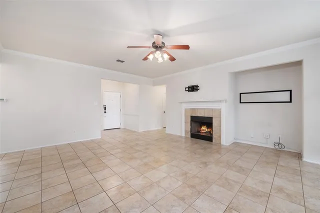 a view of an empty room with window and fireplace