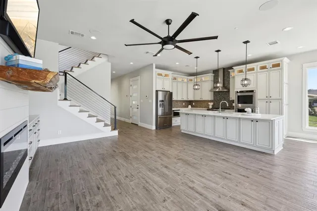 a kitchen with stainless steel appliances granite countertop a sink a stove and a refrigerator