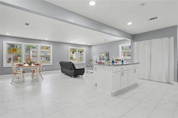 a living room with furniture and a open kitchen view