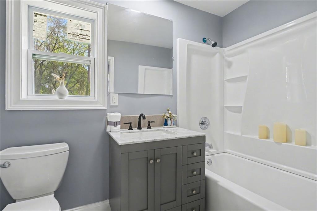 10664 Sandpiper Road Jonesboro, GA 30238 - Photo 19 of 40 a bathroom with a granite countertop sink toilet and a bathtub