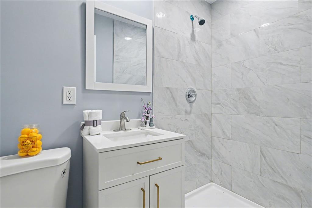 10664 Sandpiper Road Jonesboro, GA 30238 - Photo 23 of 40 a bathroom with a sink a toilet and a mirror