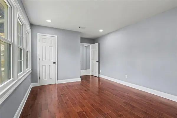 a view of hallway with window and wooden floor