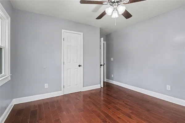 a view of an empty room with a window and wooden floor