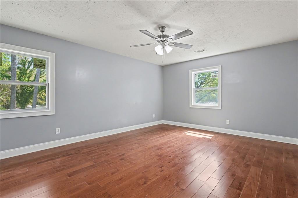 10664 Sandpiper Road Jonesboro, GA 30238 - Photo 31 of 40 a view of an empty room with a window and wooden floor