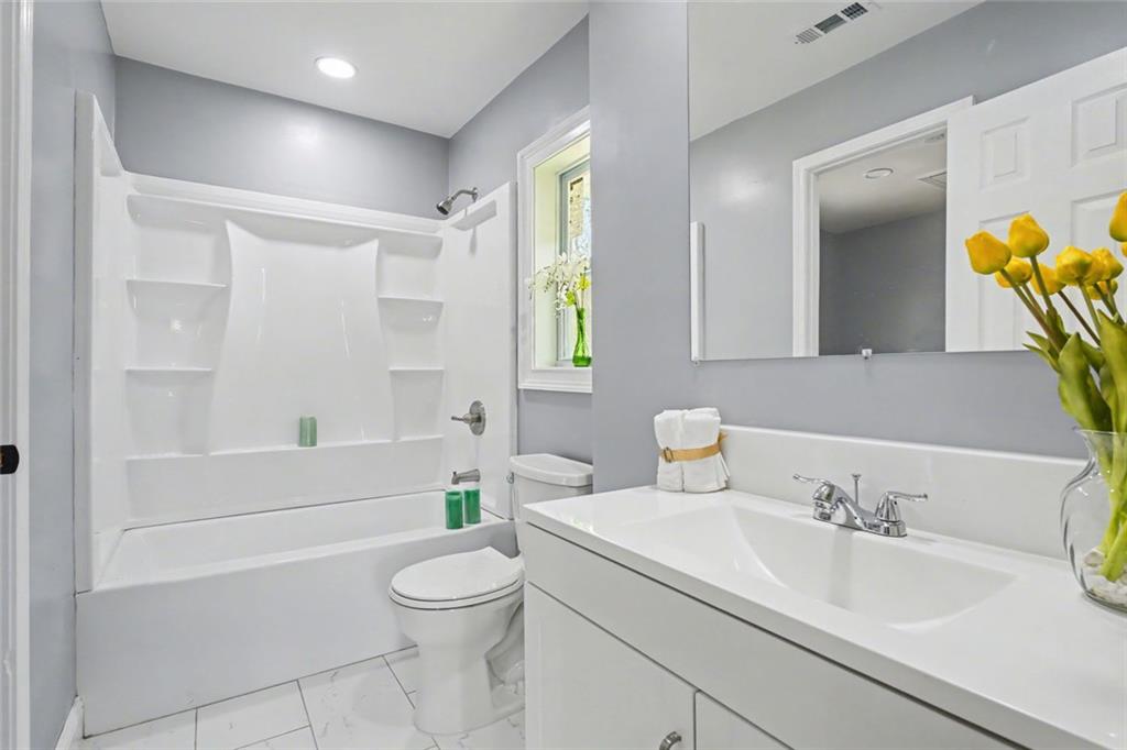10664 Sandpiper Road Jonesboro, GA 30238 - Photo 33 of 40 a bathroom with a sink a toilet and shower