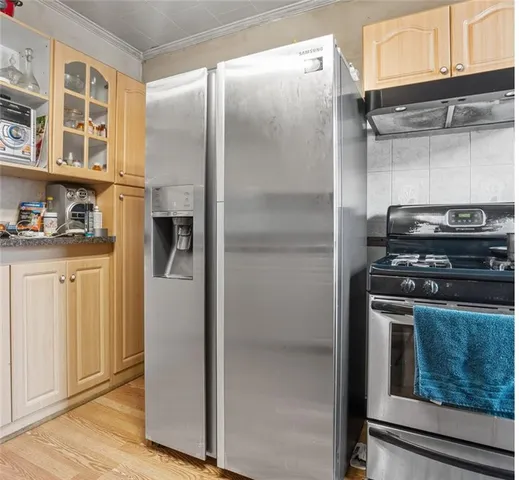 a kitchen with stainless steel appliances granite countertop a refrigerator and a stove